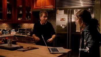 a man and a woman are standing in a kitchen with a laptop on the counter and the words global on the bottom right