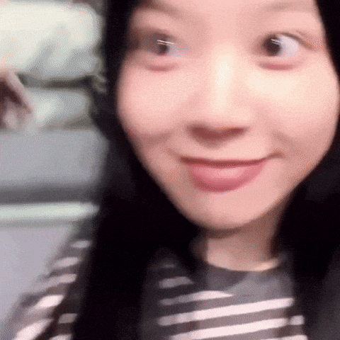 a close up of a woman 's face with a striped shirt on