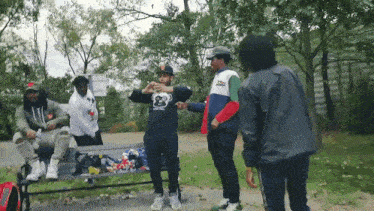 a group of men are standing around a bench with one wearing a shirt that says ' monkey ' on it