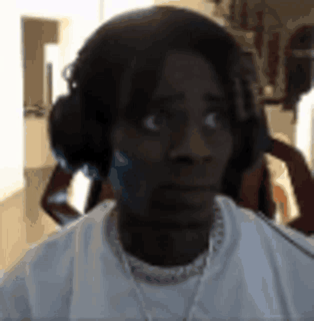 a close up of a person wearing headphones and a white shirt .