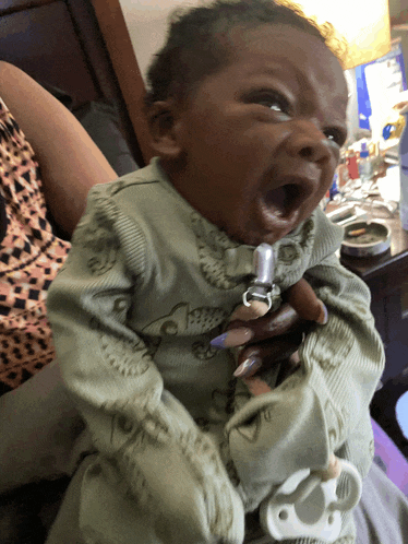 a baby with a pacifier attached to it is yawning
