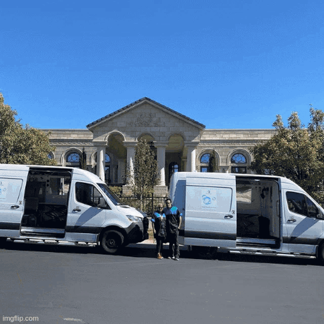 two white vans are parked in front of a building that says ' a ' on the side