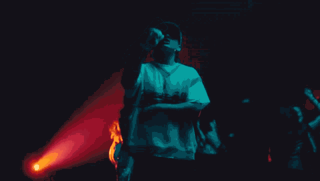 a man singing into a microphone while wearing a white shirt that says ' abercrombie & fitch ' on it