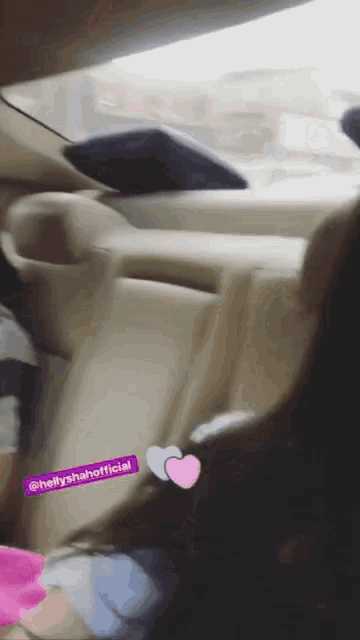 a person sitting in the back seat of a car with a purple sticker that says hellyrahaofficial on it