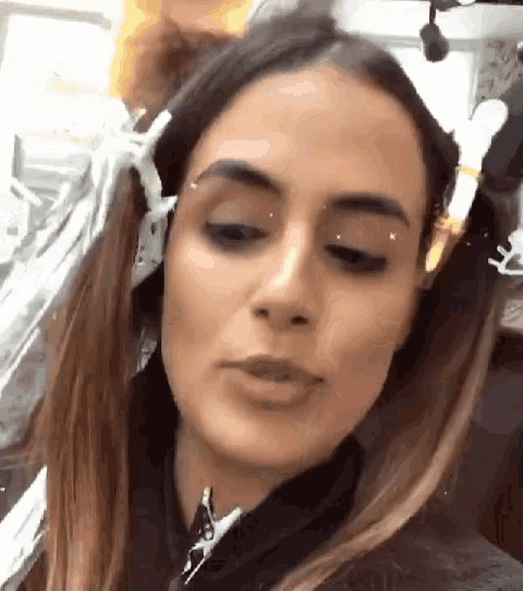a close up of a woman 's face with her hair in a bun .
