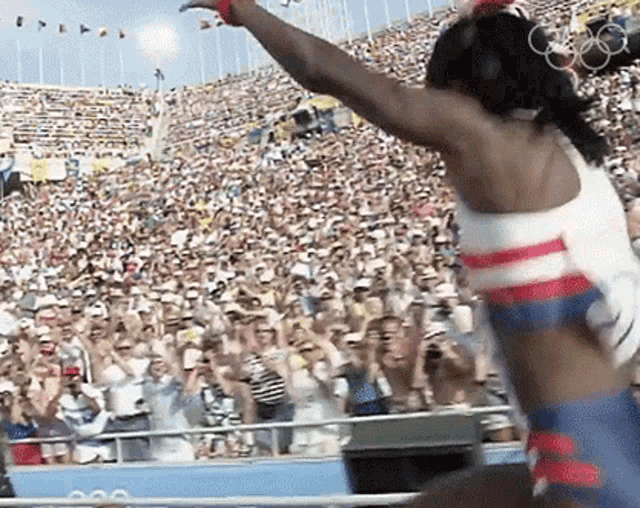 a woman in a red white and blue outfit stands in front of a crowd of people