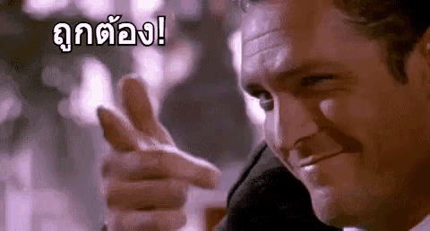 a man in a suit is pointing his finger at something .