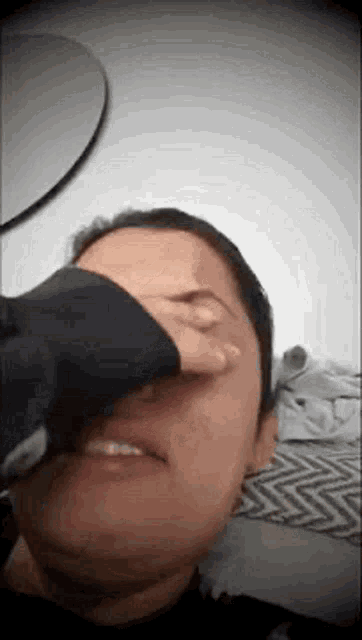 a close up of a person covering their face with a hand .