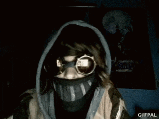 a person wearing a mask and sunglasses is making a funny face .