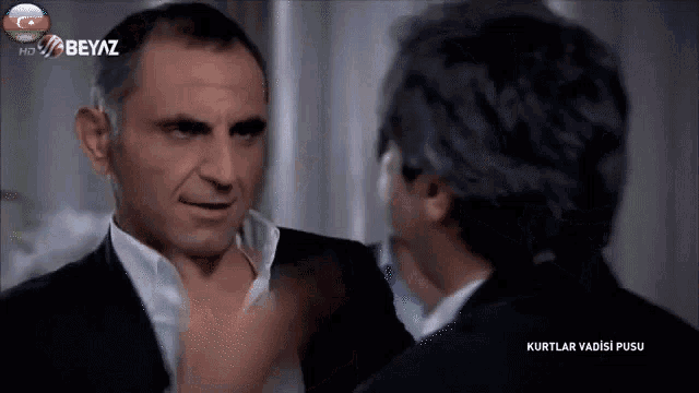 two men are standing next to each other with the words kurtlar vadisi pusu on the screen