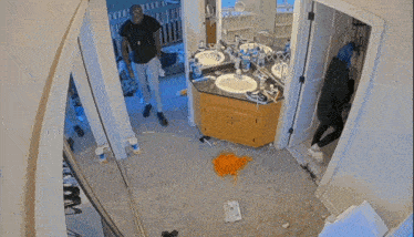 a man is squatting down in a bathroom with a mop