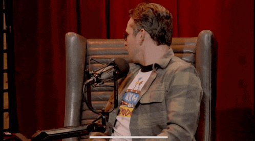 a man sitting in front of a microphone with a shirt that says ayk4