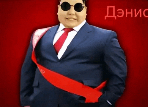 a man in a suit and tie is wearing sunglasses and a red sash ..