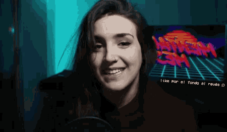 a woman is smiling in front of a screen that says like por al fondo al reverso