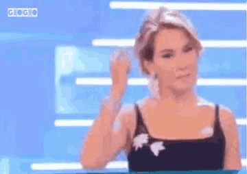 a woman in a black tank top is making a funny face .