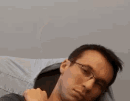 a man wearing glasses and a watch is making a middle finger gesture .