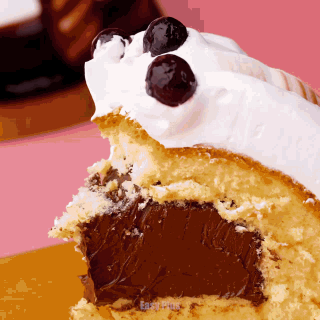 a close up of a cupcake with a bite taken out of it and the words east plus on the bottom