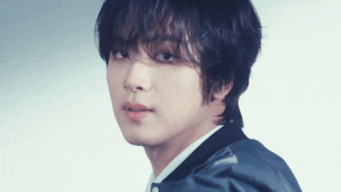 a close up of a young man 's face with a serious look on his face