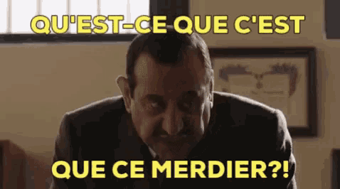 a man in a suit and tie is looking at the camera with the words que ce merdier written above him