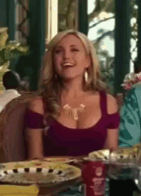 a woman in a red off the shoulder top is sitting at a table with plates and a coke can