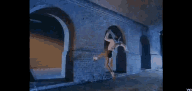 a woman is hanging from a ceiling in a building .
