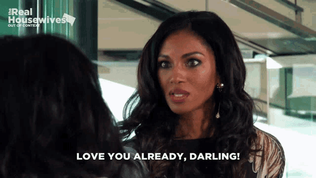 a woman says " love you already darling " in front of a real housewives ad