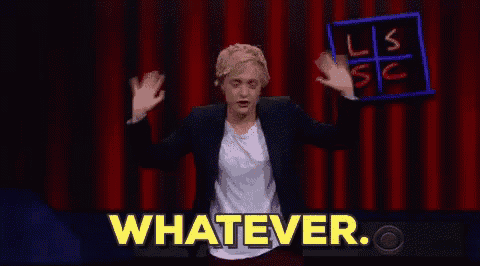 a woman stands in front of a red curtain and says " whatever "