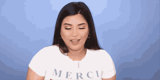 a woman wearing a white t-shirt that says merci