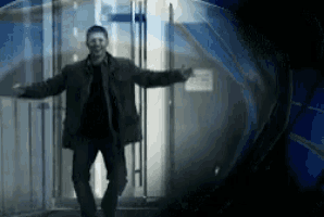 a man with his arms outstretched is standing in front of a door