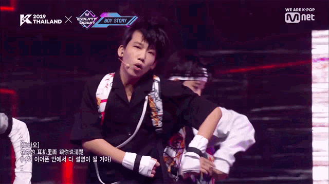 a boy is performing on a stage with the words we are k-pop on the bottom right