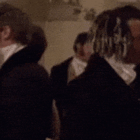 a blurry picture of a man with dreadlocks standing in a dark room .