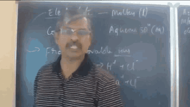 a man stands in front of a blackboard that says " ele "