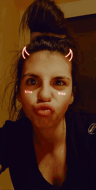 a woman with devil horns on her head and kiss written on her face