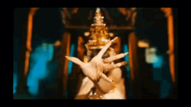 a woman is wearing a gold crown and dancing in a dark room .
