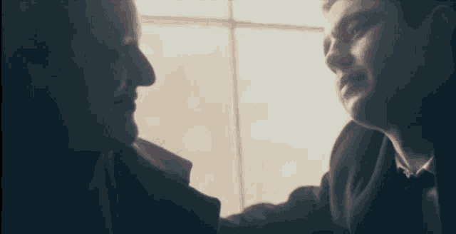 a man and a woman are looking at each other and smiling