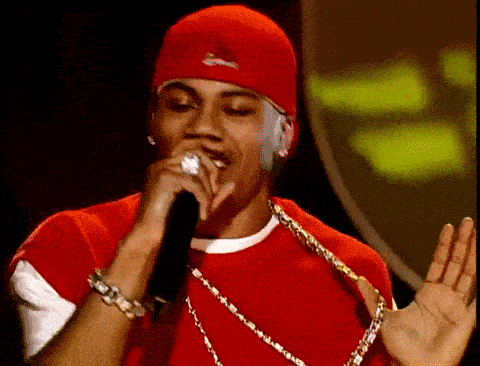 a man singing into a microphone wearing a red hat and a red shirt