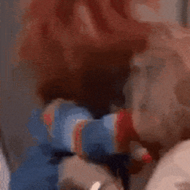a close up of a person holding a stuffed animal with blood on it .