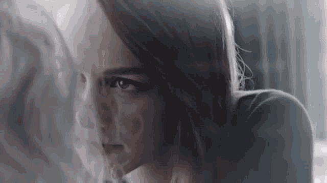 a close up of a woman 's face with smoke coming out of her eyes .