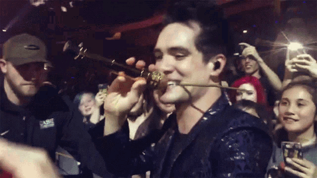 a man holding a trumpet in front of a crowd of people