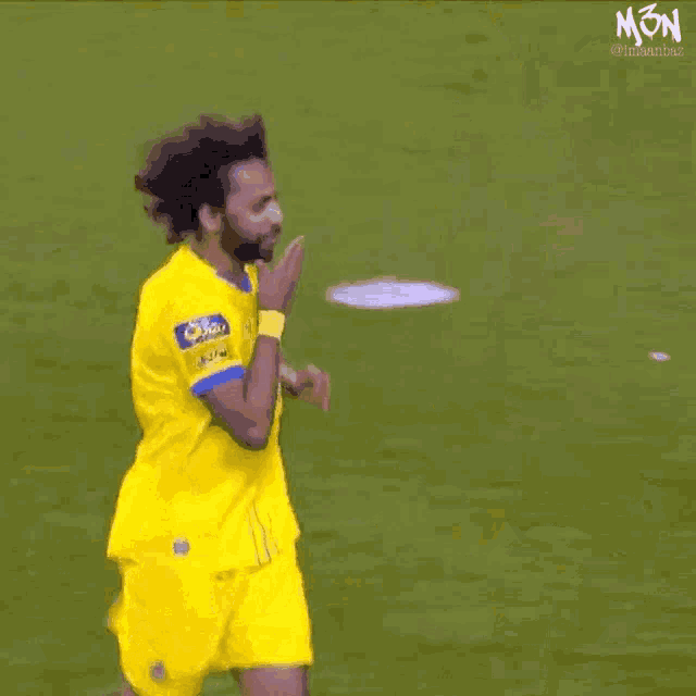a soccer player wearing a yellow jersey that says mon on it