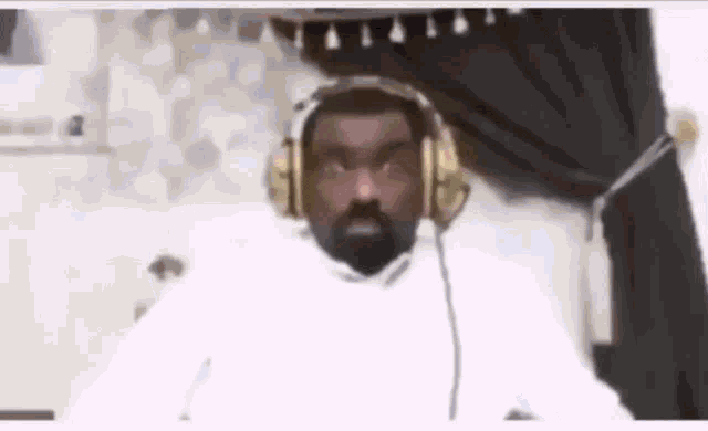 a man with a beard is wearing headphones .