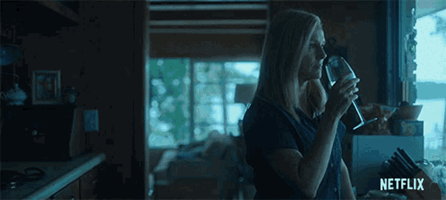 a woman drinking from a glass with netflix written on the bottom right