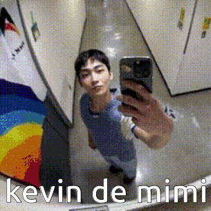 a man is taking a selfie in front of a mirror with the name kevin de mimi on the bottom