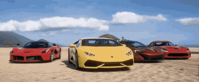 three sports cars are parked on a beach including a yellow lamborghini