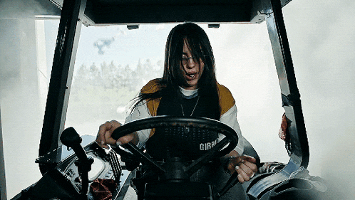 a woman wearing a shirt that says girl is driving a tractor