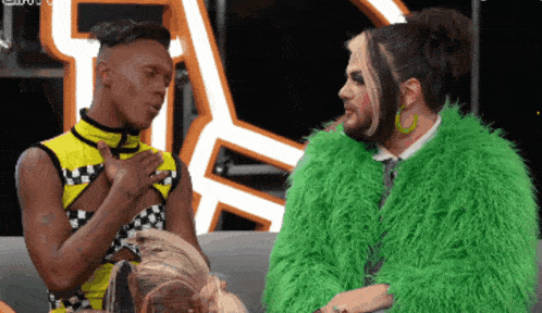 a man in a green fur coat sits next to a woman