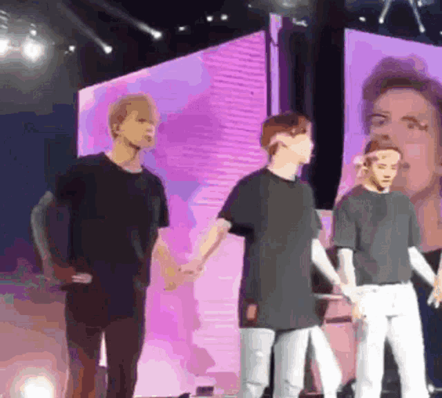 a group of men holding hands on a stage