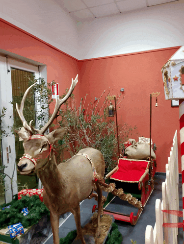 a statue of a reindeer pulling a sleigh with gifts in it