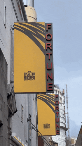 a yellow sign that says operation mincemeat hangs from the side of a building