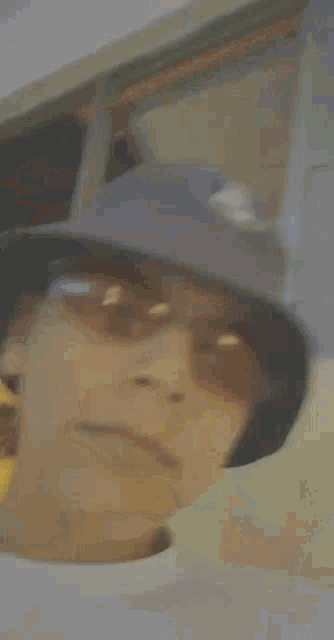 a young man wearing a hat and sunglasses takes a selfie